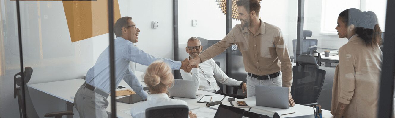 Successful business people shaking hands while having a meeting with colleagues in conference room in the modern office